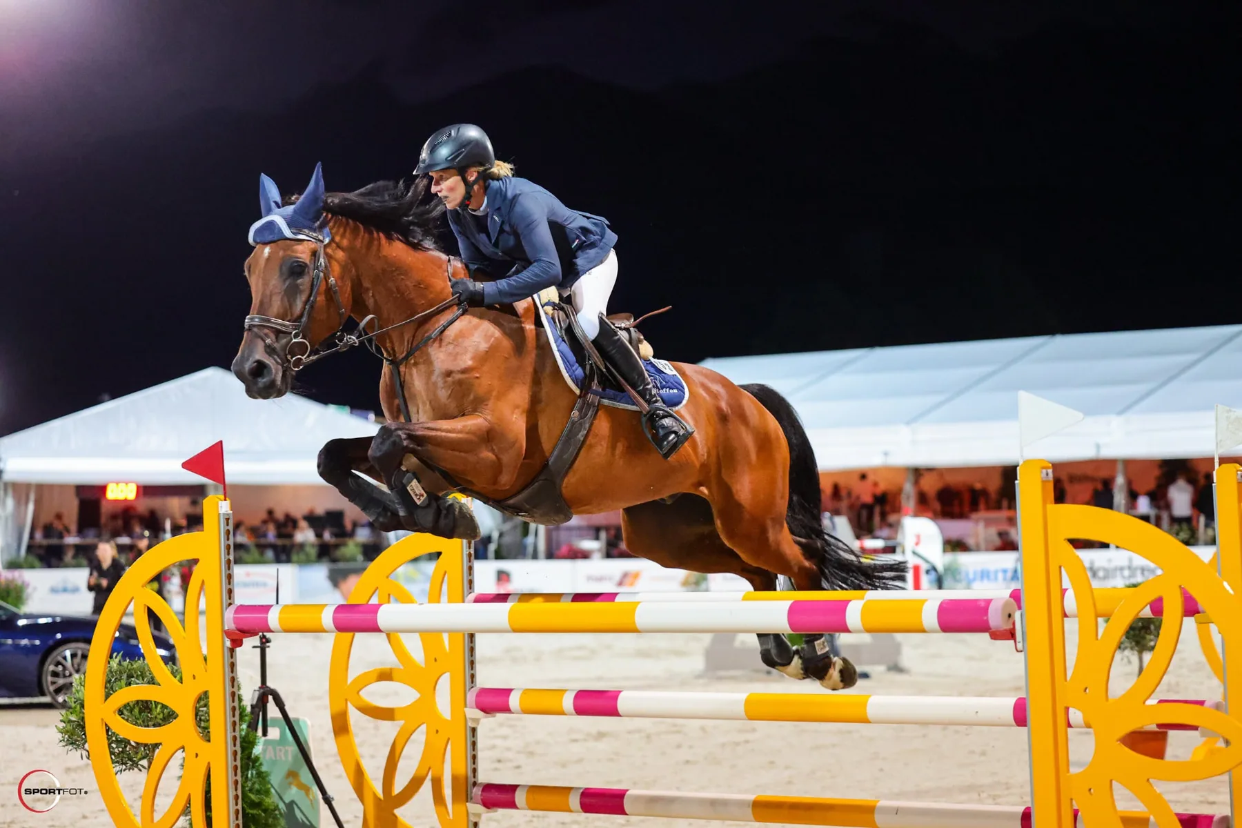 Abendspringen – Team Steffen Braunes Springpferd mit Reiterin im Sprung über ein Hindernis am Abendturnier
